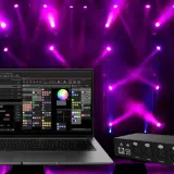 Laptop mit DMX-Software und Lichtpult im Hintergrund, bereit für eine beeindruckende Lichtshow.