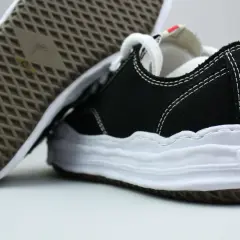 Schwarze Sneaker mit weißer Sohle und Nähten, typisch für japanische Sneaker Marken.
