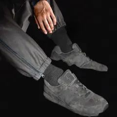 Graue Stone Island Ultras Sneaker mit Reißverschluss an der Hose.