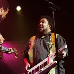 George Duke spielt Keytar und Bassgitarre auf der Bühne.