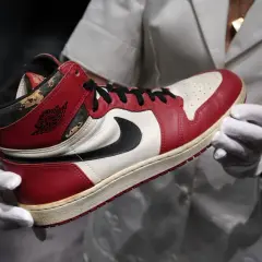 Ein Paar Air Jordan 1 Sneaker, die 1000 € teuersten Schuhe der Welt, werden mit weißen Handschuhen präsentiert.
