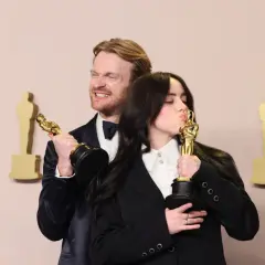 Billie Eilish küsst ihren Oscar, während ihr Bruder Finneas ihn hält. Ein Moment, der die Frage "billie eilish what was i made for?" beantwortet.