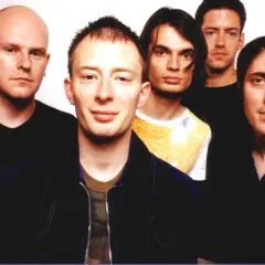 Fünf Mitglieder von Radiohead posieren für ein Foto. Thom Yorke steht im Vordergrund, flankiert von seinen Bandkollegen.