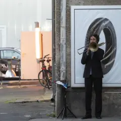 Nicholas Collins spielt Posaune vor einem riesigen Reifenbild.