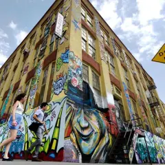 Buntes Graffiti ziert ein gelbes Gebäude in New York. Ein "Dead End"-Schild weist auf die kreative Sackgasse hin.