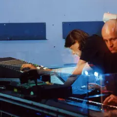 Robert Henke und Kollegin im Studio, umgeben von blauem Licht und Musik-Equipment.