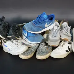 Bunte Sneaker-Sammlung, darunter blaue Nike-Schuhe. Die Frage, wo werden Nike Schuhe hergestellt, bleibt offen.