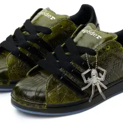 Grüne Adidas Superstar Sneaker mit Spinnennetz-Muster und Spinnen-Anhänger. Ein Highlight der Adidas Kollaborationen.