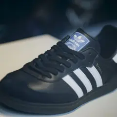 Schwarzer Adidas Samba Schuh mit weißen Streifen und goldener "SAMBA"-Prägung. Ein Klassiker, der seinen Preis wert ist – einer der teuersten Adidas Schuhe.