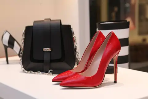 Glänzende rote Pumps und eine schwarze Tasche, die die teuersten Schuhe der Welt für Damen repräsentieren könnten.