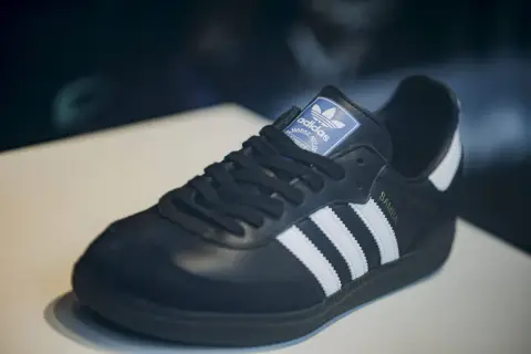 Schwarzer Adidas Samba Schuh mit weißen Streifen und goldener "SAMBA"-Prägung. Ein Klassiker, der seinen Preis wert ist – einer der teuersten Adidas Schuhe.