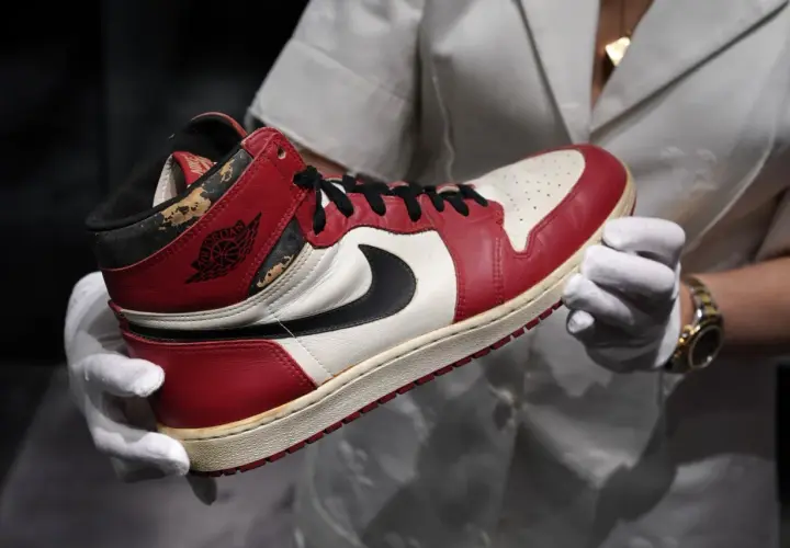 Ein Paar Air Jordan 1 Sneaker, die 1000 € teuersten Schuhe der Welt, werden mit weißen Handschuhen präsentiert.