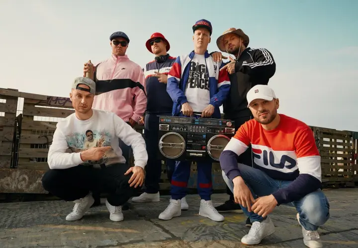 Sechs Männer in Hip-Hop-Kleidung mit einer Boombox. Sie zeigen, was ist rap: ein Lebensgefühl, Musik und Style.