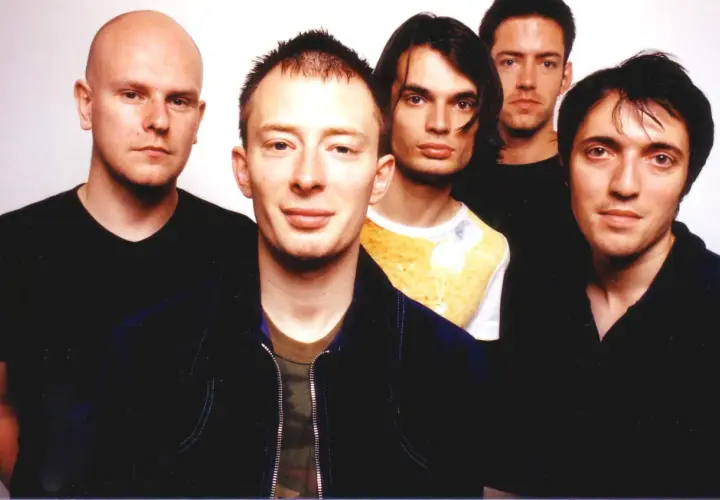 Fünf Mitglieder von Radiohead posieren für ein Foto. Thom Yorke steht im Vordergrund, flankiert von seinen Bandkollegen.