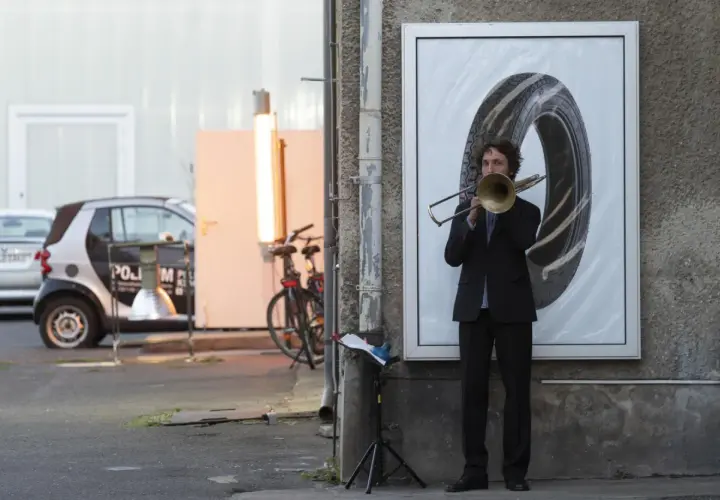 Nicholas Collins spielt Posaune vor einem riesigen Reifenbild.