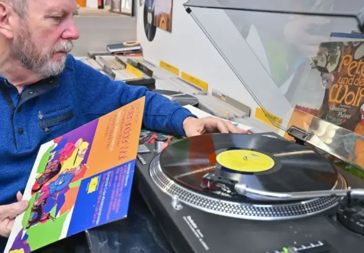 Mann wählt eine DDR-Schallplatte aus, um sie als DJ aufzulegen.