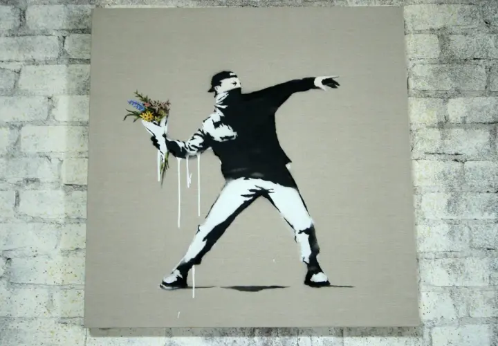 Ein Mann wirft Blumen statt eines Molotowcocktails. Das ist typisch für Banksy, der mit seiner Kunst zum Nachdenken anregt.