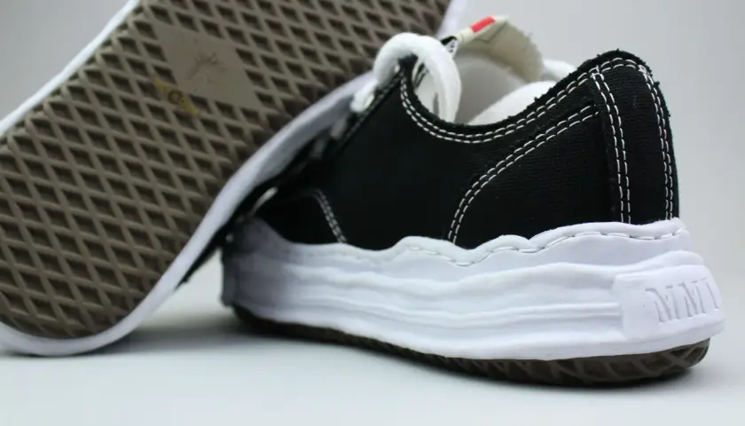 Schwarze Sneaker mit weißer Sohle und Nähten, typisch für japanische Sneaker Marken.