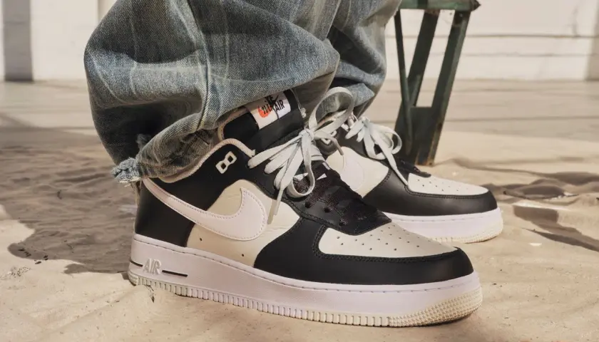 Nike Air Force 1 in Schwarz-Weiß. Die Frage, wie fallen Nike Air Force 1 aus, wird hier durch den lässigen Look mit Jeans beantwortet.