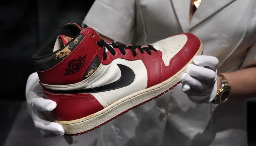 Ein Paar Air Jordan 1 Sneaker, die 1000 € teuersten Schuhe der Welt, werden mit weißen Handschuhen präsentiert.