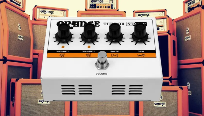 Ein Orange Terror Stamp Pedal steht im Vordergrund, umgeben von vielen Orange Verstärkern.
