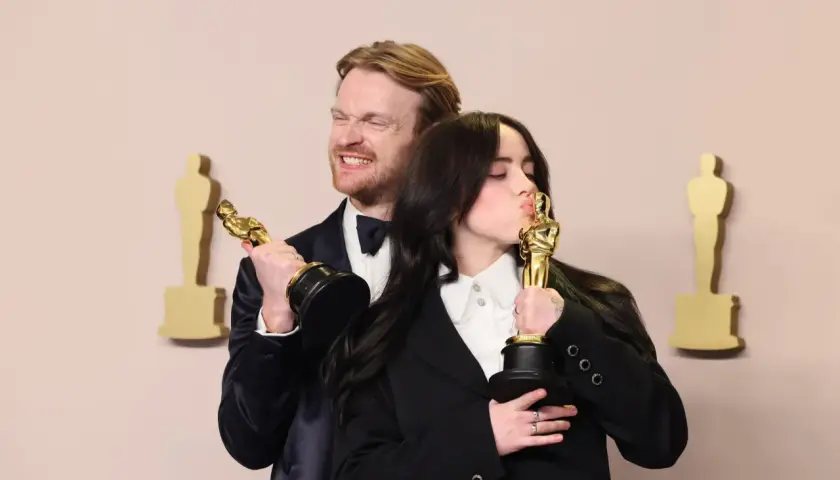 Billie Eilish küsst ihren Oscar, während ihr Bruder Finneas ihn hält. Ein Moment, der die Frage "billie eilish what was i made for?" beantwortet.