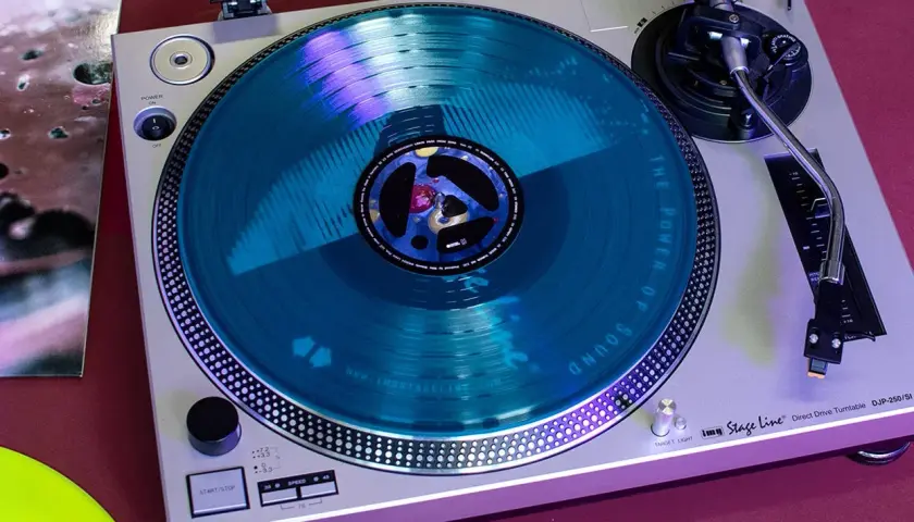 Ein Plattenspieler mit einer blauen Schallplatte. Perfekt für das Schallplatten waschen, um den besten Sound zu genießen.