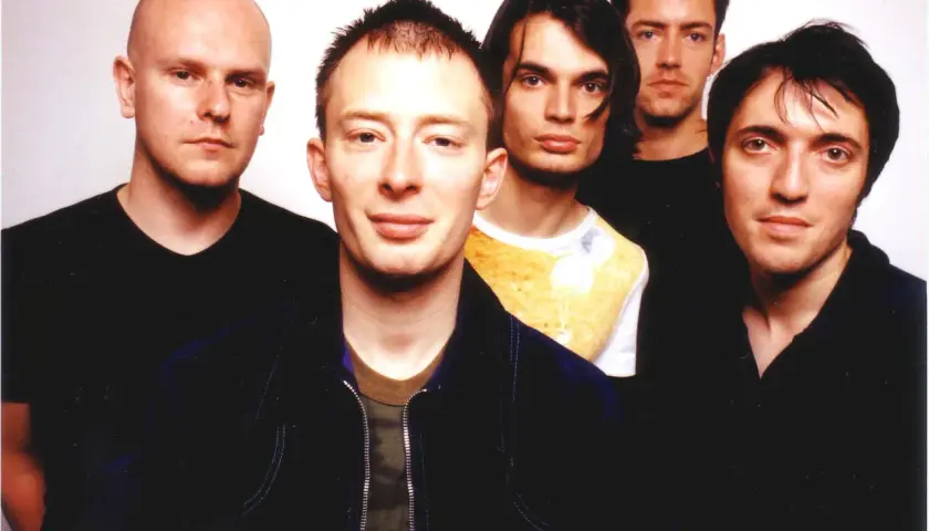 Fünf Mitglieder von Radiohead posieren für ein Foto. Thom Yorke steht im Vordergrund, flankiert von seinen Bandkollegen.
