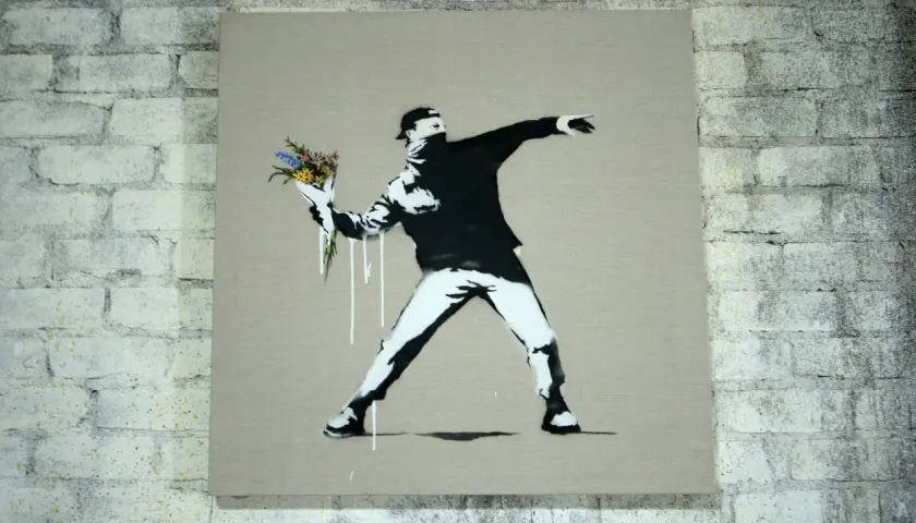 Ein Mann wirft Blumen statt eines Molotowcocktails. Das ist typisch für Banksy, der mit seiner Kunst zum Nachdenken anregt.