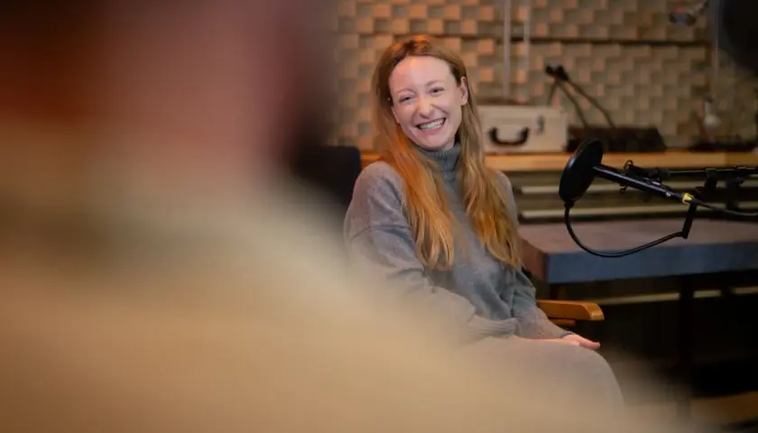 Simon Triebel lacht herzlich in einem Aufnahmestudio, bereit für ein Interview.