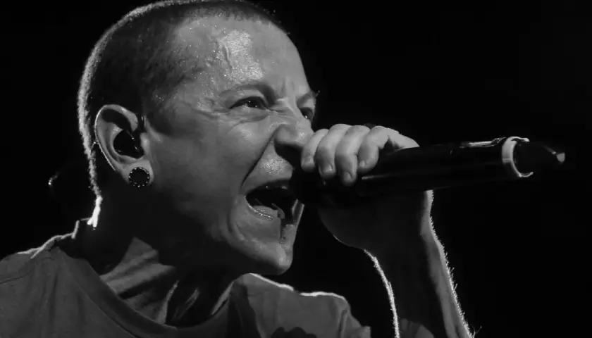 Linkin Park's Chester Bennington singt mit voller Leidenschaft ins Mikrofon, Schweißperlen auf der Stirn.
