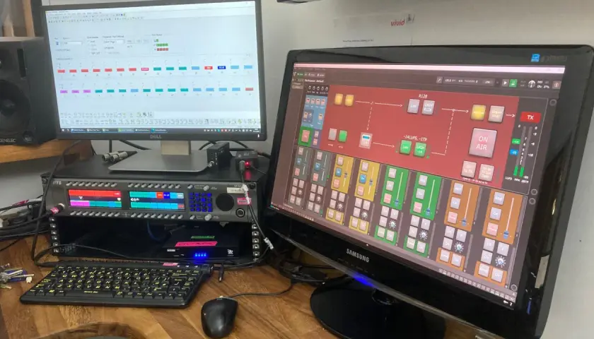 Ein gig performer steuert mit zwei Monitoren und einem Rack-Mixer die Audioübertragung.