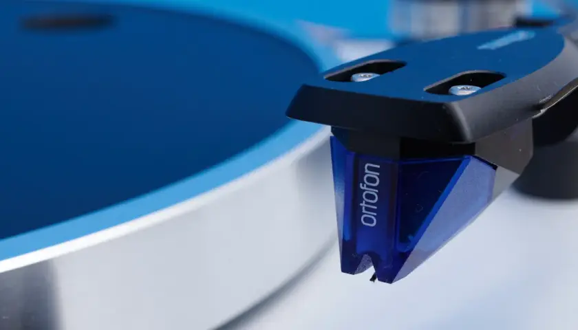 Nahaufnahme des Ortofon 2M Blue Tonabnehmers, bereit für einen Test auf einem Plattenspieler.