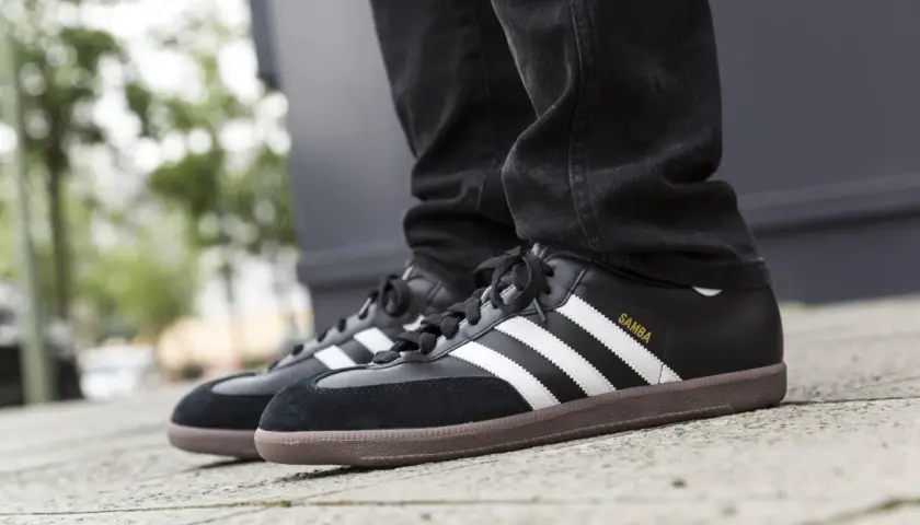 Schwarze Adidas Samba Sneaker mit brauner Gummisohle und weißen Streifen. Sie fallen größengerecht aus und passen gut zu Jeans.