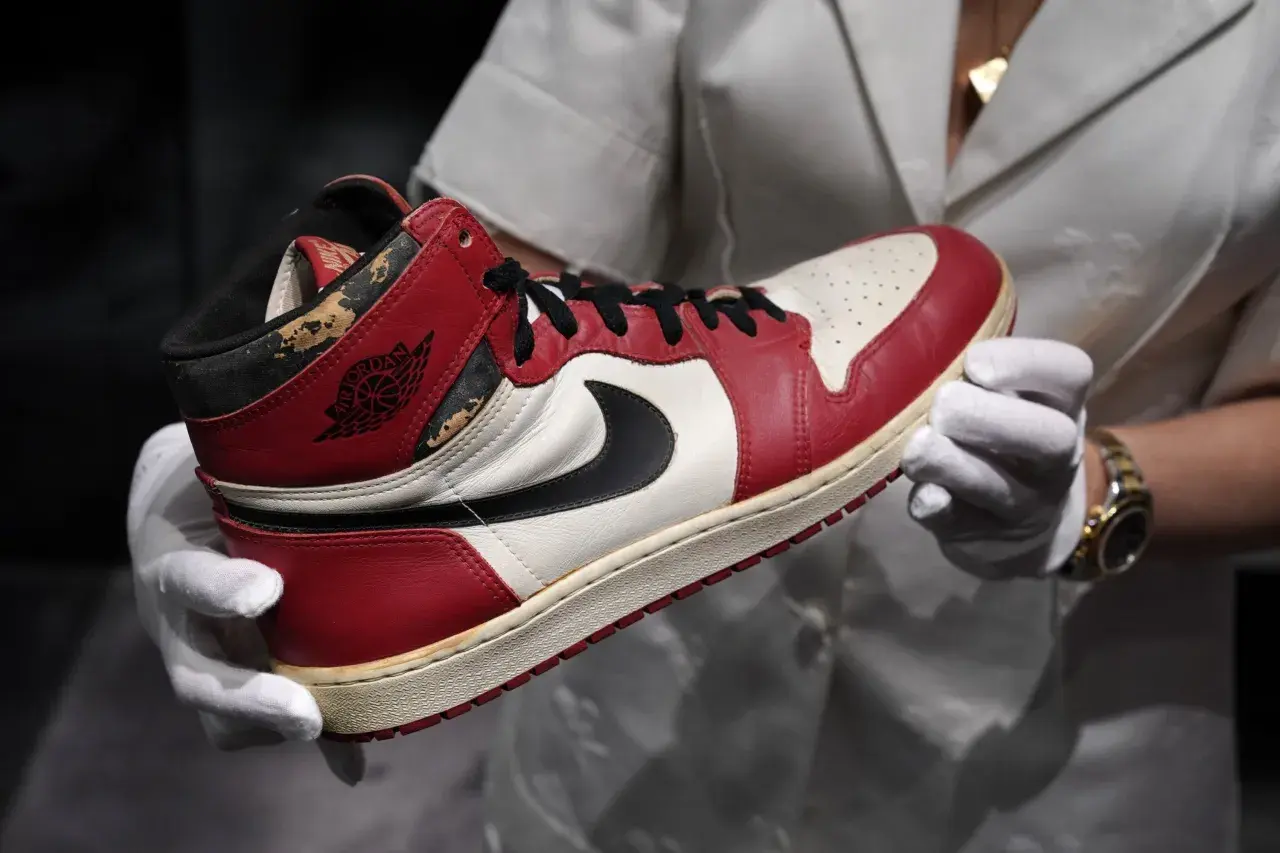 Ein Paar Air Jordan 1 Sneaker, die 1000 € teuersten Schuhe der Welt, werden mit weißen Handschuhen präsentiert.