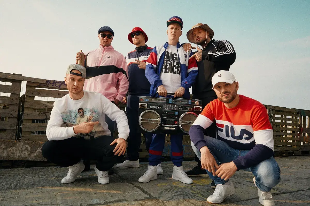 Sechs Männer in Hip-Hop-Kleidung mit einer Boombox. Sie zeigen, was ist rap: ein Lebensgefühl, Musik und Style.