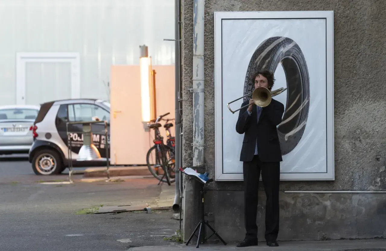 Nicholas Collins spielt Posaune vor einem riesigen Reifenbild.