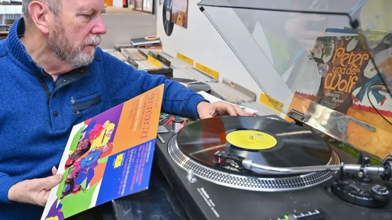 Mann wählt eine DDR-Schallplatte aus, um sie als DJ aufzulegen.