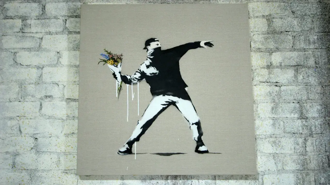 Ein Mann wirft Blumen statt eines Molotowcocktails. Das ist typisch für Banksy, der mit seiner Kunst zum Nachdenken anregt.
