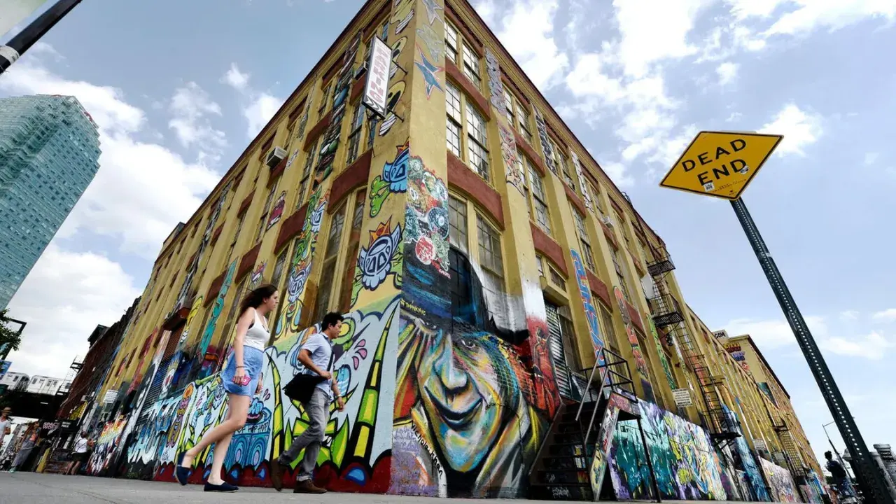 Buntes Graffiti ziert ein gelbes Gebäude in New York. Ein "Dead End"-Schild weist auf die kreative Sackgasse hin.