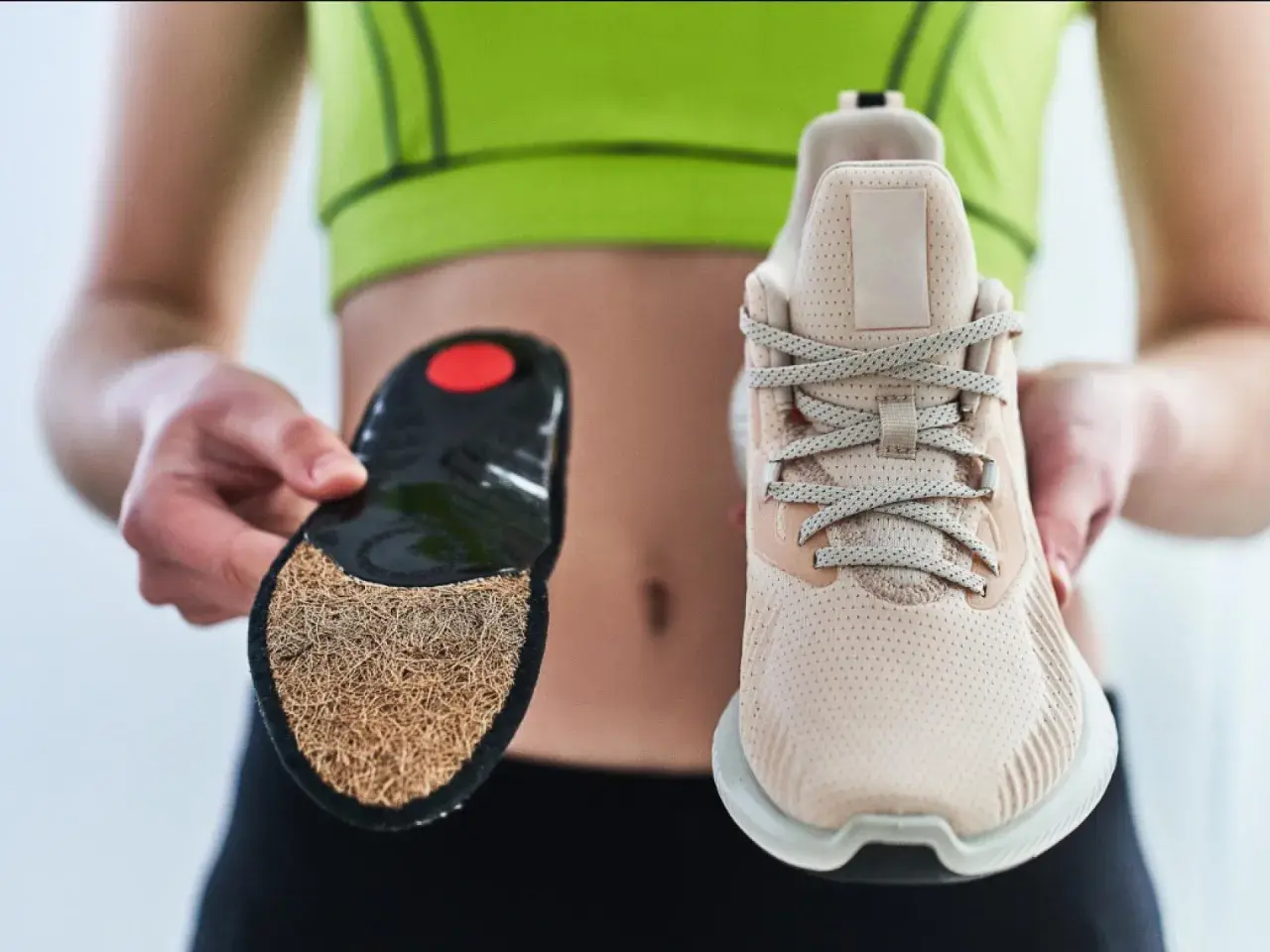 Ein Sneaker und eine Einlegesohle werden gezeigt. Der Aufbau des Schuhs wird durch die separate Einlage verdeutlicht.