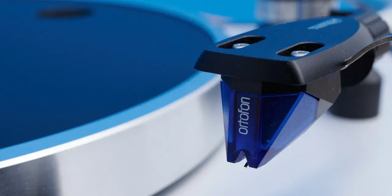 Nahaufnahme des Ortofon 2M Blue Tonabnehmers, bereit für einen Test auf einem Plattenspieler.