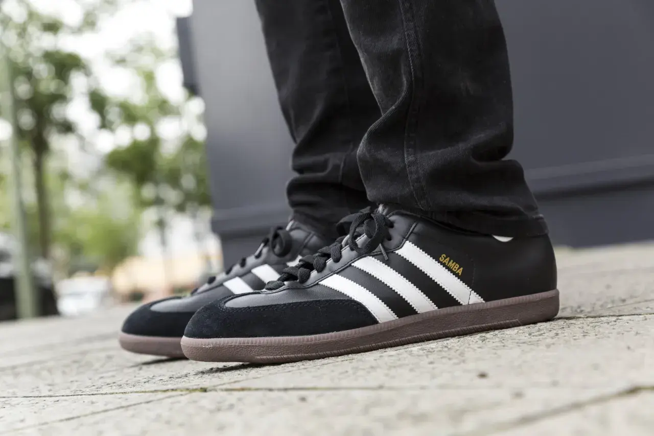 Schwarze Adidas Samba Sneaker mit brauner Gummisohle und weißen Streifen. Sie fallen größengerecht aus und passen gut zu Jeans.