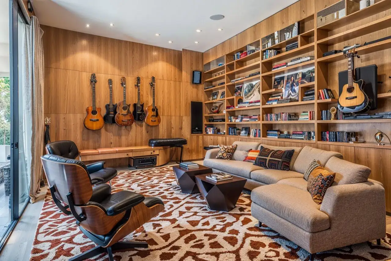 Ein stilvolles Wohnzimmer mit Holzw&auml;nden, Gitarren, B&uuml;cherregalen und bequemen M&ouml;beln. Tolle konzeptkunst beispiele f&uuml;r ein musikalisches Zuhause.