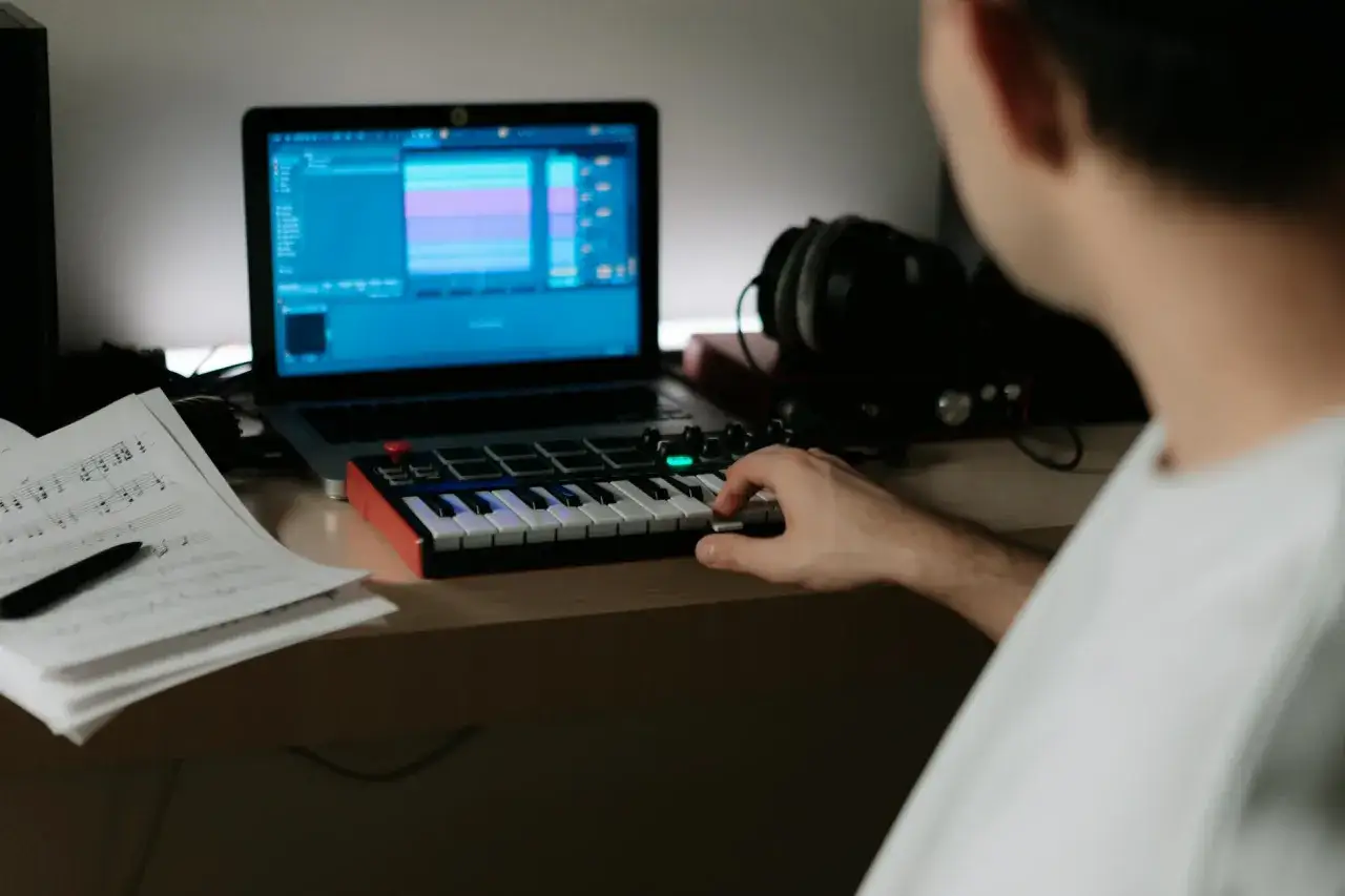 Ein Musiker spielt auf einem Ableton Push 3 Standalone, w&auml;hrend Noten und ein Laptop daneben liegen.