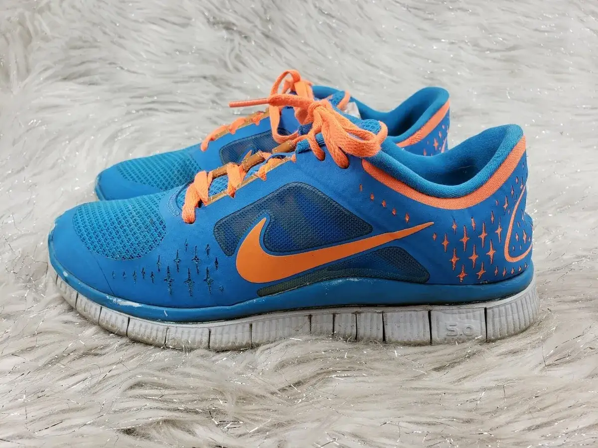 Blaue Nike Free Rush Laufschuhe mit orangefarbenen Schnürsenkeln und Akzenten. Perfekt für den schnellen Lauf.