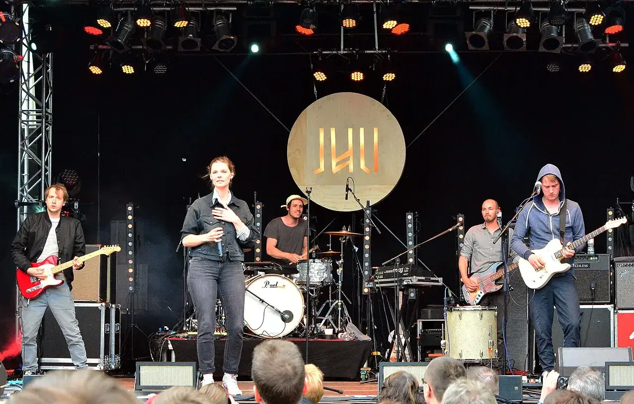 Simon Triebel mit Band auf der B&uuml;hne. S&auml;ngerin im Vordergrund, Gitarristen und Schlagzeuger im Hintergrund.