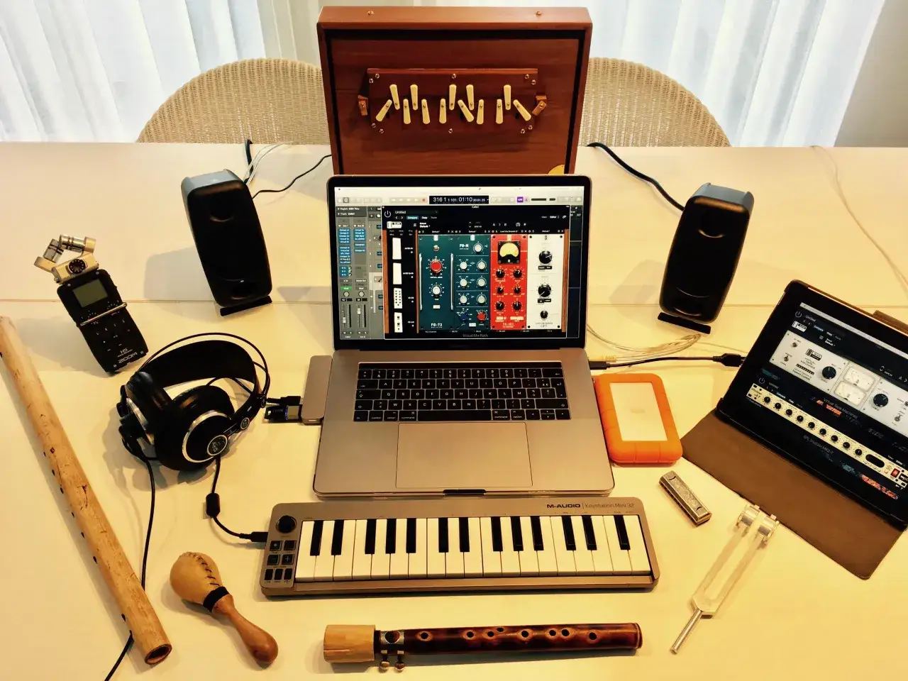 Musikproduktion mit Laptop, Lautsprechern, Kopfhörern, Mini-Keyboard und einem Tascam X8-Rekorder.