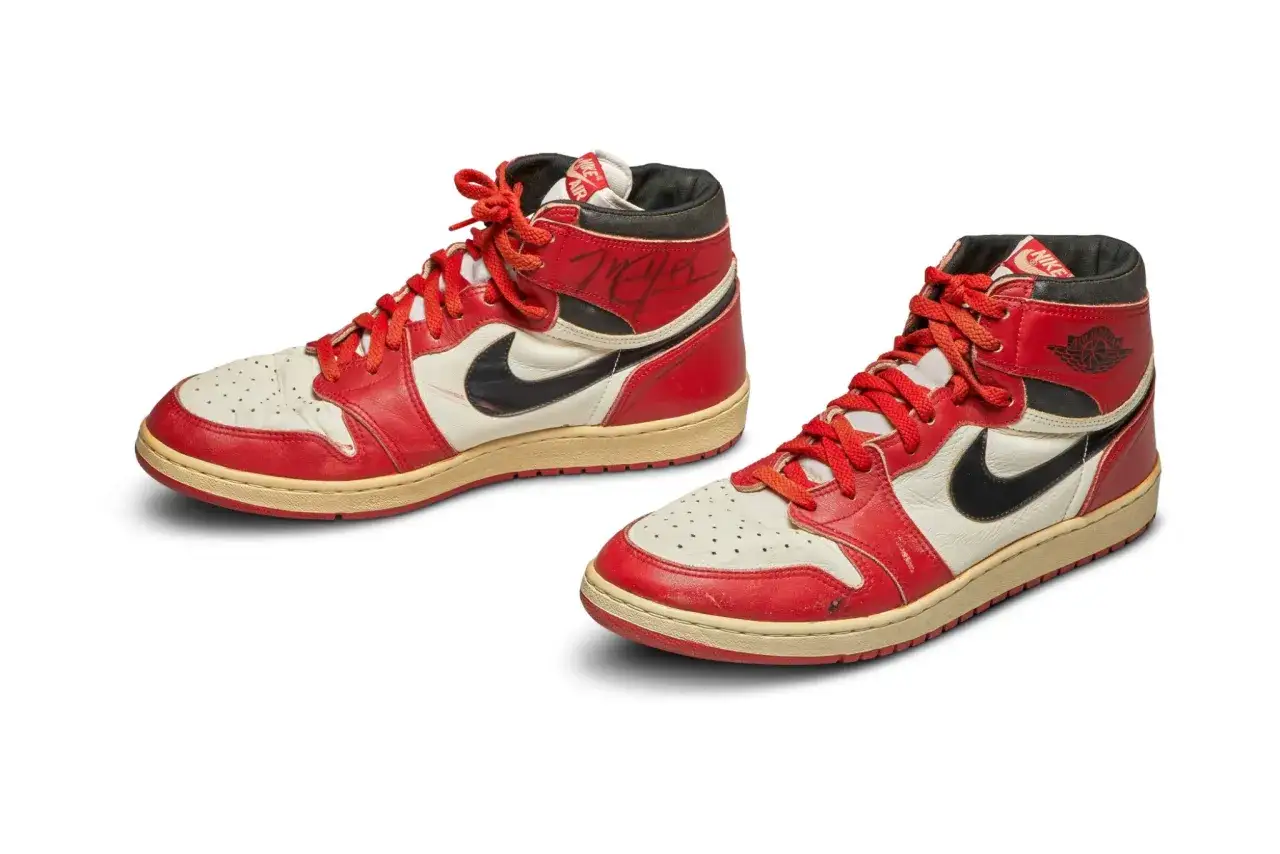 Zwei rote und wei&szlig;e Air Jordan 1 Highs, der teuerste Jordan, mit schwarzem Nike-Swoosh und Schn&uuml;rsenkeln, einer signiert.