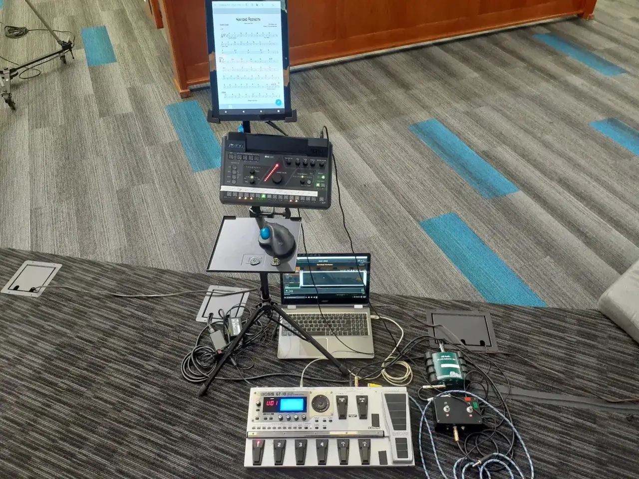 Ein gig performer bereitet seine Ausr&uuml;stung vor: Tablet mit Noten, Laptop, Mischpult und Gitarren-Effektpedale.